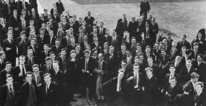 A monochrome photograph showing a large group of students gathered in academic dress for the opening ceremony.