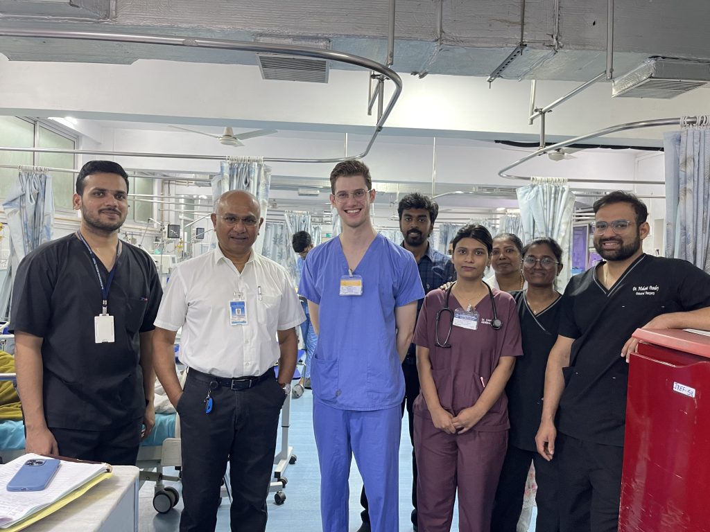 Oliver Cujic in medical scrubs with other hospital staff.