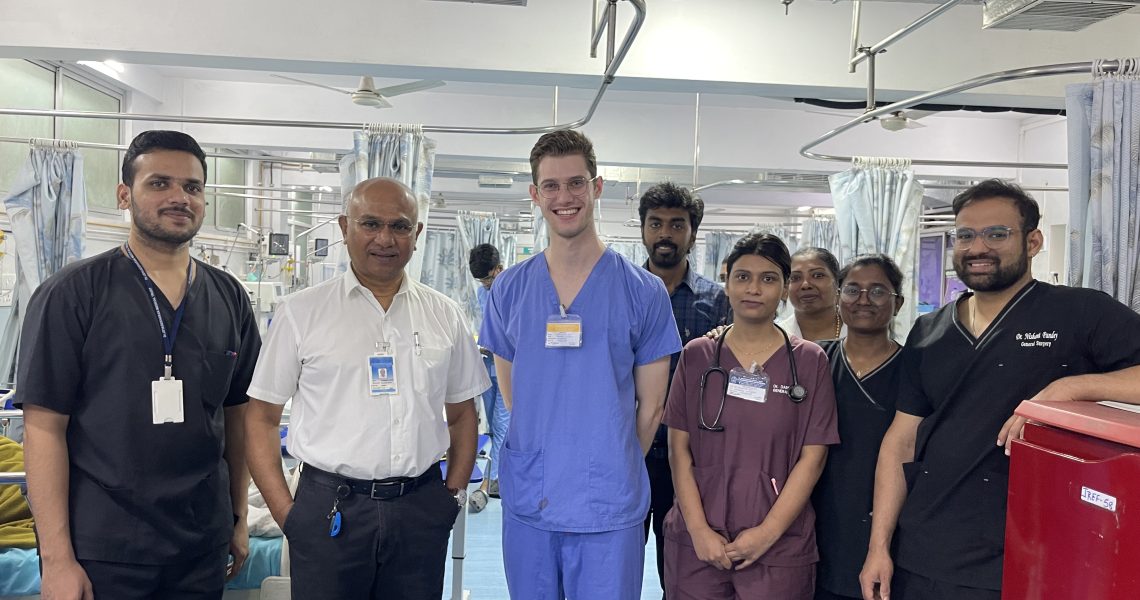 Oliver Cujic in medical scrubs with other hospital staff.